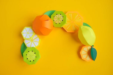 Kağıttan meyveler. Sarı arka plan. Yazmak için yer var. Tropik bölgeler.