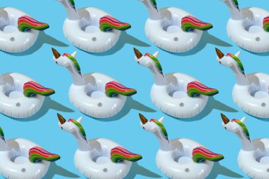 Pastel mavi arka planda şişirilebilir tek boynuzlu at havuz oyuncağı deseni. Asgari yaz konsepti.