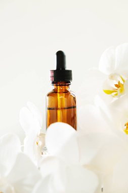 Beyaz arka planda beyaz çiçekli bir yağ şişesi.