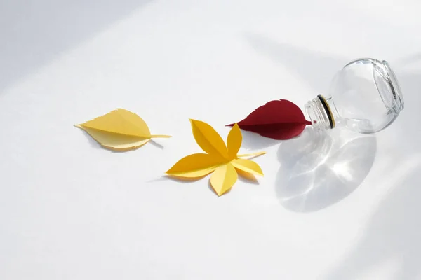 Leaves of paper fall red, orange, yellow leaf fall on white background. Abstract fall concept