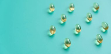 Mavi arka planda balık yağı kapsülleri. Omega-3