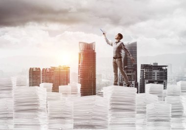 Rahat kıyafet ise cityscape belgelerle yığını üzerinde duran ve arka plan üzerinde güneş ışığı el kitabı ile uydurarak erkekte yan görünüm. Karışık teknik.