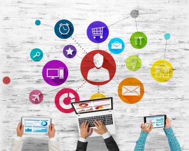 Ellerinde cihazlar bulunan üç kişilik bir grup iletişim ve ağ oluşturma sembolü olarak birlikte çalışıyor.