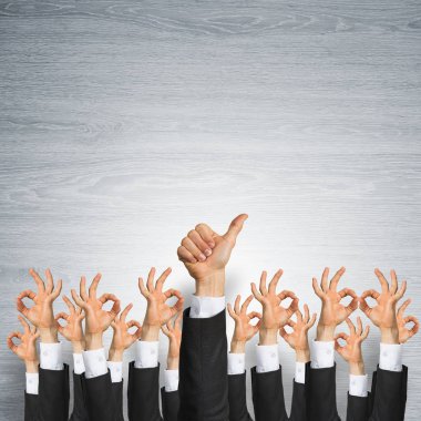 Bir grup iş adamı ahşap arka planda jestler gösteriyor.