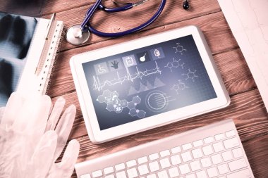 Beyaz tablet bilgisayar ve doktor aletleri ahşap masada.