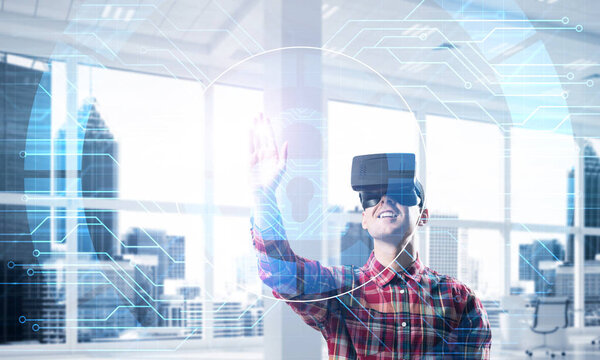 Парень в клетчатой рубашке и виртуальной гарнитуре работает с панелью мультимедийного экрана
