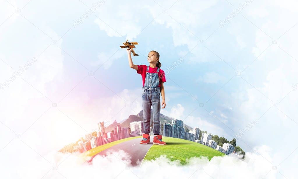 Cute kid girl on city floating island playing with retro plane model