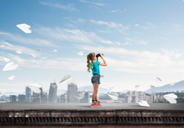 Dürbünle bakan, okul çağındaki sevimli kız çatıyı inşa ediyor.