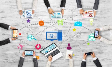 Ellerinde cihazlar bulunan bir grup insan, iletişim ve ağın sembolü olarak birlikte çalışıyor.