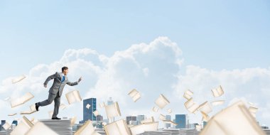 Takım elbise ile telefonu elinde kitap Clear sky ile arka plan üzerinde uçan arasında çalışan iş adamı. Karışık teknik.