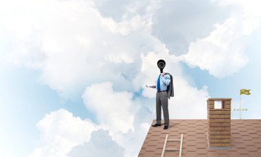 Evin çatısında baş durmak yerine kamerayla zum yapan yüzü olmayan bir iş adamı.