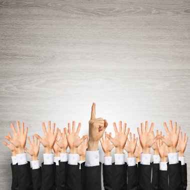 Bir grup iş adamı ahşap arka planda jestler gösteriyor.