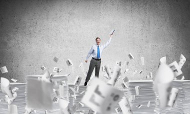 Gri arka plan belgelerle uçan arasında duran el kitabı ile uydurarak iş adamı. Karışık teknik.