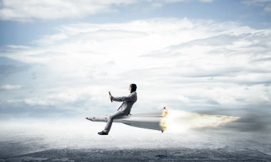 Zemin üzerine mavi bulutlu gökyüzü ile roket yukarıda asfalt yol üzerinde uçan takım elbiseli genç işadamı kavramsal görüntü.