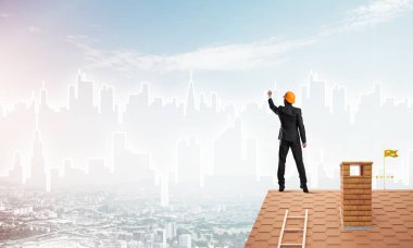 Mühendis, evinin çatısına geri döndü ve şehri çiziyor. Karışık ortam