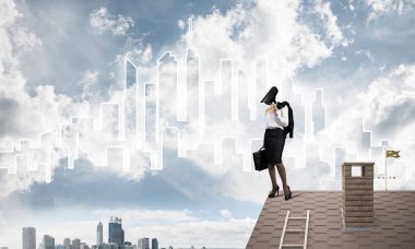 Evin çatısında baş durmak yerine kamerayla zum yapan yüzsüz iş kadını.