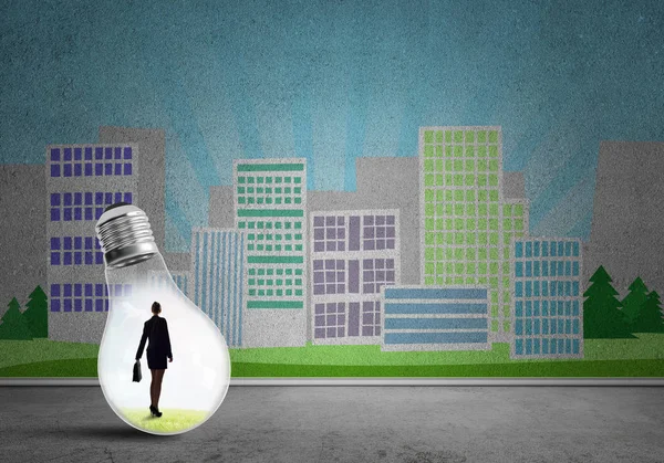 都市に対する電球の中のビジネスマンがコンセプトを描いた — ストック写真