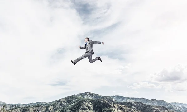 Businessman in suit running in the air as symbol of active life position. Skyscape and nature view on background. 3D rendering.