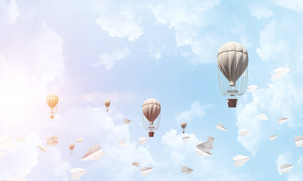 Красочные аэростаты, летающие среди бумажных самолетов и над голубым облачным небом. 3D рендеринг
.
