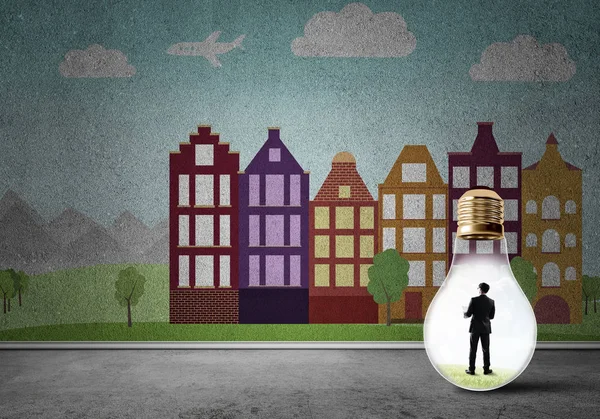 Businessman inside light bulb against city drawn concept