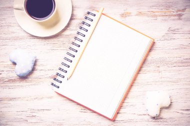 Kahve fincanı not defteri kalem ve ahşap yüzeyde iki kalp