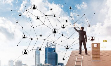 Delikanlı çatıda dikiliyor ve bağlantı hatları çiziyor. Karışık ortam