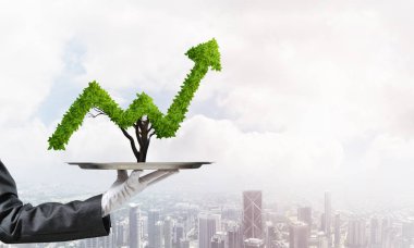 Garson kızın elinde beyaz eldiven ile cityscape arka plan üzerinde metal tepsi üzerinde yeşil büyüyen grafik sunma kırpılmış görüntü.