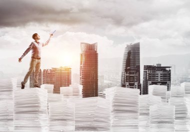 Rahat kıyafet ise cityscape belgelerle yığını üzerinde duran ve arka plan üzerinde güneş ışığı el kitabı ile uydurarak erkekte yan görünüm. Karışık teknik.