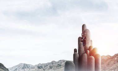 İş kadını kafasına silah tutmak yerine eski bir Tv ile takım elbiseli güzel manzara ile taş sütunlar tepesinde dururken arka plan üzerinde çarpı işareti.