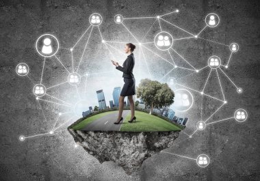 Uçan yeşil adada beton zeminde zarif bir iş kadını.