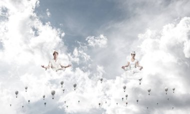 Genç çift gözleri koruma kapalı ve seyir aerostats hava bulutlu gökyüzü ile arka plan üzerinde uçan arasında meditasyon sırasında konsantre.