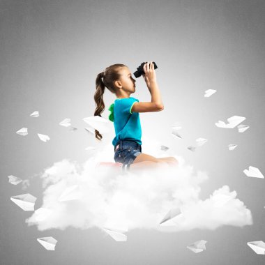 Sevimli kız dürbün ve etrafında uçan kağıt uçaklar seyir bulut üzerinde ayakta