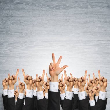 Bir grup iş adamı ahşap arka planda jestler gösteriyor.