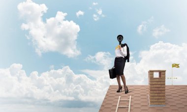 Evin çatısında baş durmak yerine kamerayla zum yapan yüzsüz iş kadını.