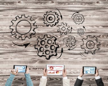 Ellerinde cihazlar bulunan üç kişilik bir grup iletişim ve ağ oluşturma sembolü olarak birlikte çalışıyor.