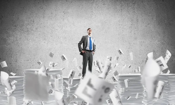 Confident Businessman Suit Standing Pile Documents Flying Papers Grey Background — Stock Photo, Image