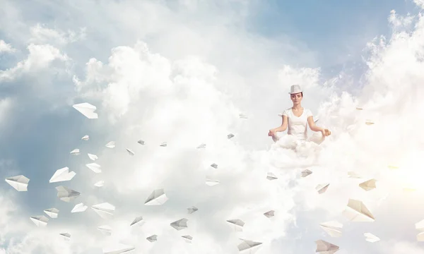 穿着白色衣服的妇女保持眼睛闭着 看着集中 而在空气中的飞行纸飞机与多云影像的背景下沉思 — 图库照片