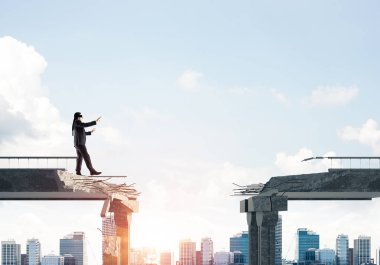 Gizli tehditlerin ve risklerin sembolü olarak beton köprüde gözü kapalı yürüyen bir iş adamı. Arka planda güneş ışığı olan şehir manzarası. 3B görüntüleme.