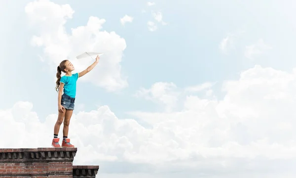 可爱的小女孩在楼顶上玩纸飞机 — 图库照片