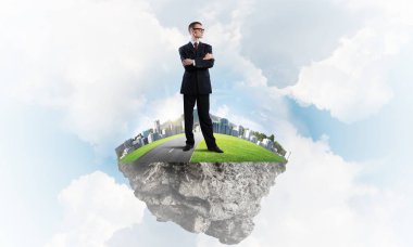 Mavi gök yeşil yüzen ada üzerinde duran zarif emin iş adamı