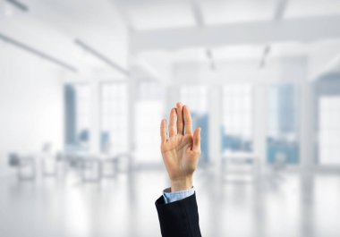 İş kadınının eli ekranda kapalı ve arka planda avuç içi ve ofis