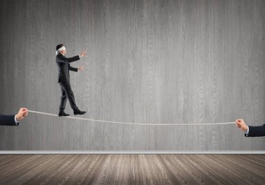 İş konsepti risk desteği ve ipte dengede duran adama yardım
