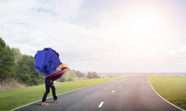 Sırtında kağıt top taşıyan inşaatçı.