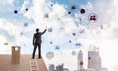 Delikanlı çatıda dikiliyor ve bağlantı hatları çiziyor. Karışık ortam