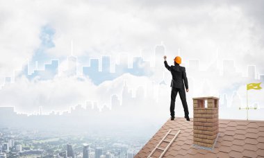 Mühendis, evinin çatısına geri döndü ve şehri çiziyor. Karışık ortam