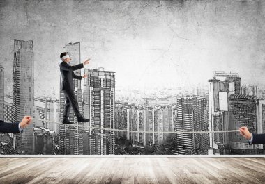 İş konsepti risk desteği ve ipte dengede duran adama yardım