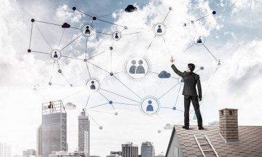 Delikanlı çatıda dikiliyor ve bağlantı hatları çiziyor. Karışık ortam