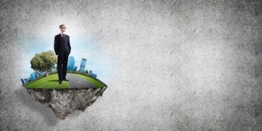 Yeşil yüzen adada beton zemine karşı duran kendine güvenen zarif iş adamı.