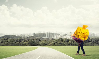 Sırtında kağıt top taşıyan inşaatçı.