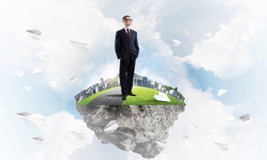 Mavi gök yeşil yüzen ada üzerinde duran zarif emin iş adamı